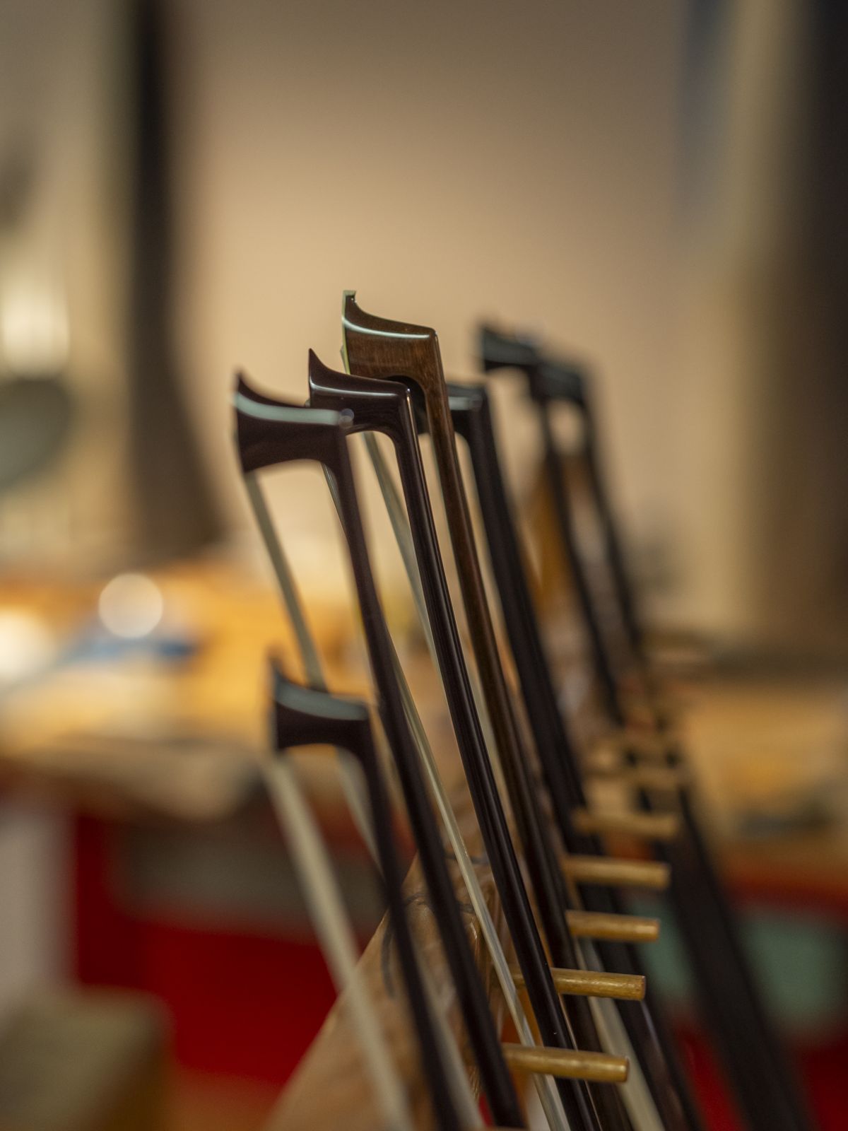 Row of bow heads standing in a rack, in soft focus against the workshop