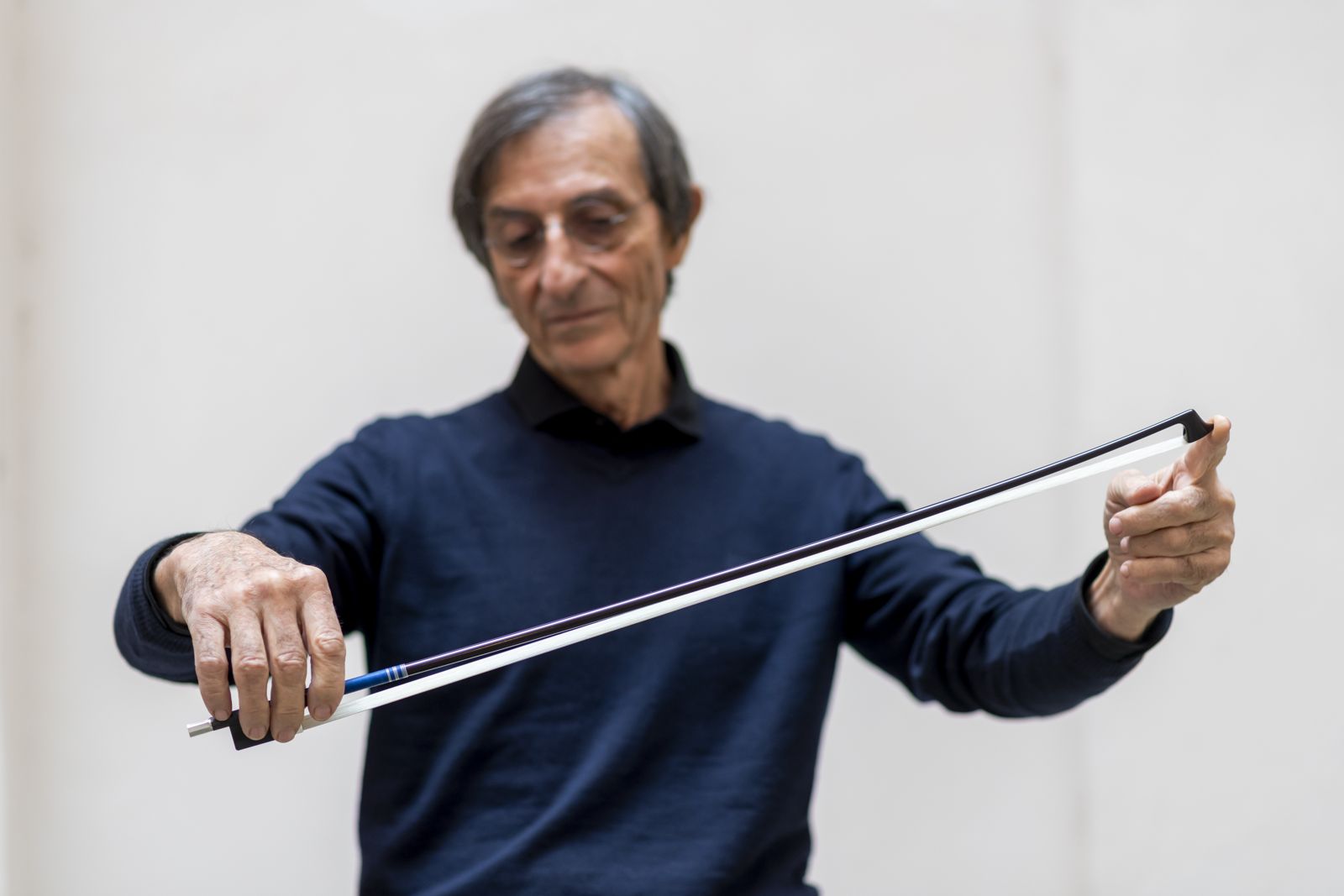 Gilles Saurais holding a bow by the frog and the tip, feeling how the stick responds