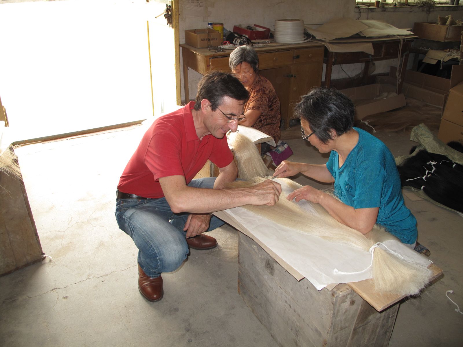 Gilles Saurais crouching beside a sorter, examining hairs on her table