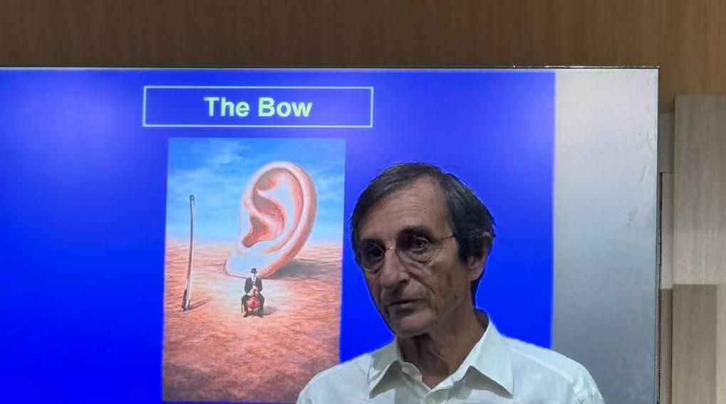 Gilles Saurais lecturing in front of a slide titled The Bow